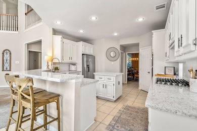 Sleek, chef-ready kitchen featuring a gas cooktop, double oven, stainless steel appliances, oversized sink, ample counters and cabinets, plus a breakfast bar for casual dining or entertaining.