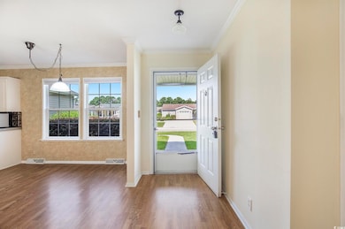 Entrance foyer featuring wood finished floors and ornamental molding