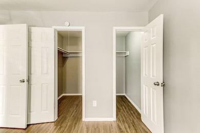 Unfurnished bedroom with a spacious closet and wood finished floors