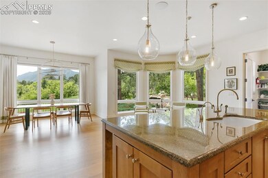 Kitchen with a sink, brown cabinetry, light wood-style floors, recessed lighting, and decorative light fixtures