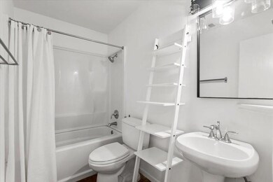 Bathroom featuring toilet, a sink, and shower / b