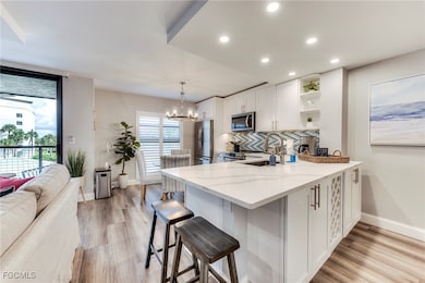 Kitchen with tasteful backsplash, white cabinets, plenty of natural light, a peninsula, and recessed lighting