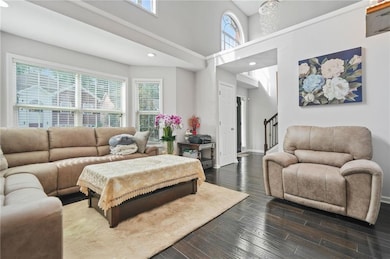 Living area with dark wood-type flooring, a toweri