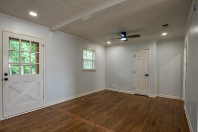 Empty room featuring ornamental molding, dark wood finished floors, a ceiling fan, recessed lighting, and beamed ceiling