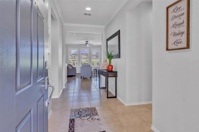 Foyer featuring ornamental molding, ceiling fan, a