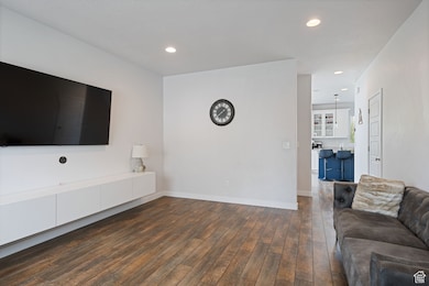 Unfurnished living room featuring recessed lighting and dark wood-style floors