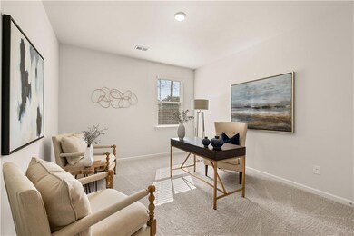 Office space with light carpet, visible vents, and baseboards