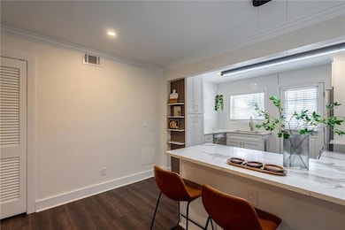 Dining space featuring ornamental molding, dark wood finished floors, baseboards, and recessed lighting