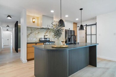 Kitchen featuring stainless steel stove, dark cou