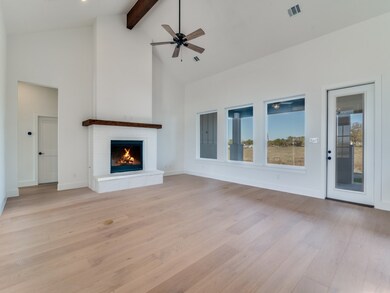 Unfurnished living room featuring high vaulted ceiling, beamed ceiling, light wood-style flooring, a fireplace, and a ceiling fan