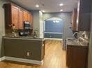 Kitchen featuring wood finished floors, recessed lighting, and brown cabinetry