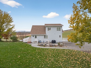 Back of house featuring a yard, a patio, and a shingled roof