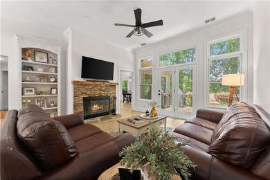 Living area featuring ornamental molding, a ceiling fan, light wood-style flooring, and a fireplace