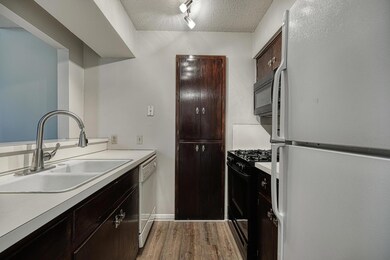 Kitchen with black appliances, a textured ceiling