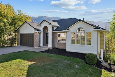 Ranch-style home with a mountain view, concrete driveway, brick siding, and a front yard