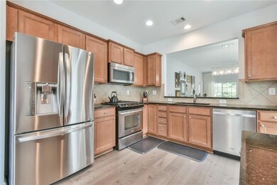 Kitchen featuring stainless steel appliances, a sink, light wood-style flooring, tasteful backsplash, and recessed lighting
