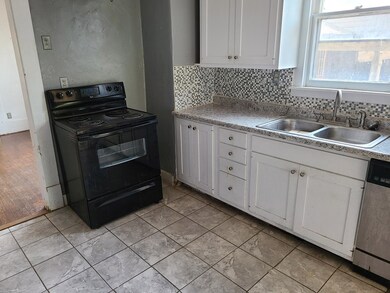 Kitchen featuring white cabinetry, black electric range oven, tasteful backsplash, stainless steel dishwasher, and light countertops