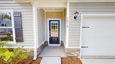 Property entrance featuring stone siding and a garage