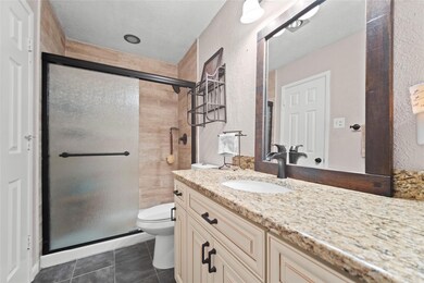 Bathroom featuring toilet, walk in shower, tile pa