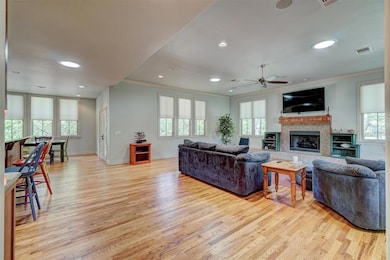 Living room with crown molding, light wood-type fl