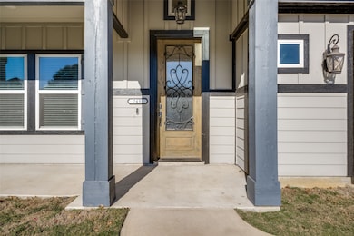 View of exterior entry with a porch and board and batten siding