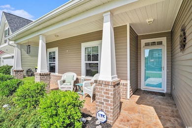 Entrance to property with covered porch, a shingled roof, and brick siding