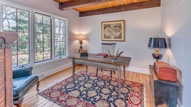 Striking Beam First Floor Den with Hardwood Floors