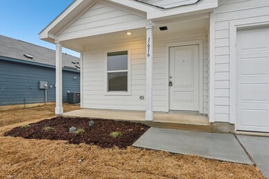 View of front facade with a garage and cooling uni