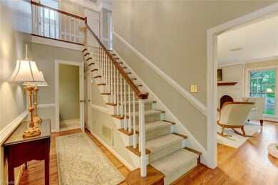 THE 2 STORY FOYER HAS BEAUTIFUL HARDWOOD FLOORS, CROWN MOLDINGS AND CHAIRRAIL.