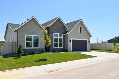 View of front of home with driveway, a gate, brick siding, and a shingled roof