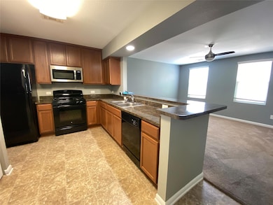 Kitchen with black appliances, a peninsula, dark 