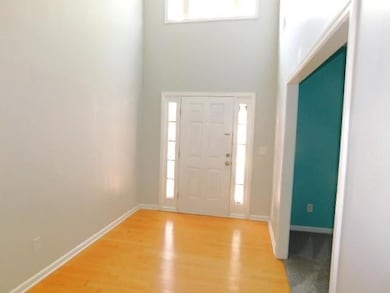 Entryway featuring light wood-style flooring and a high ceiling