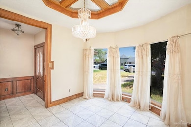 Unfurnished dining area featuring a chandelier and wainscoting
