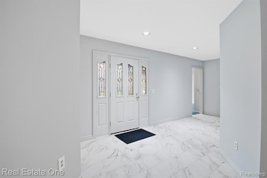 Entrance foyer with light marble finish flooring and recessed lighting