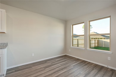 Unfurnished dining area with baseboards and wood finished floors