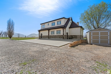 View of front of home featuring stucco siding, a chimney, a mountain view, an outbuilding, and a storage unit