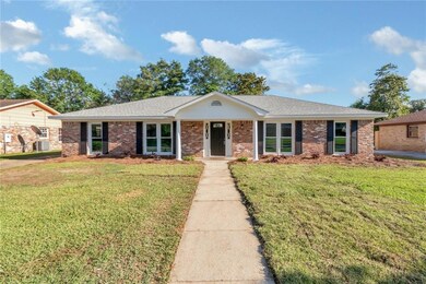 Single story home with a front lawn, brick siding, and a shingled roof