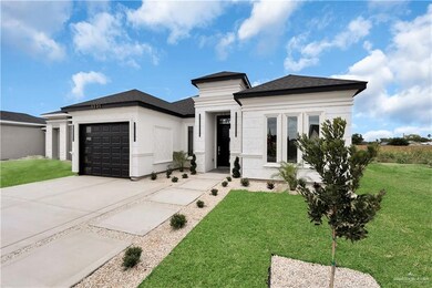 View of front of property with a garage, a front lawn, concrete driveway, and roof with shingles