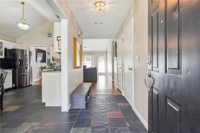 Foyer entrance with baseboards and stone tile flooring