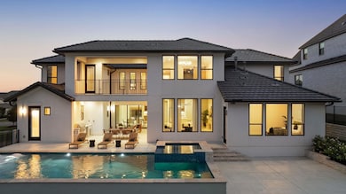 Back of house at dusk with stucco siding, a patio