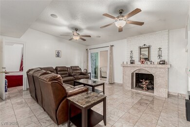 Living area with baseboards, ceiling fan, a firepl