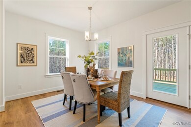 Dining area with baseboards, a chandelier, and lig