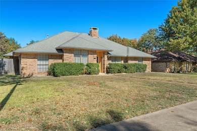 Single story home featuring a shingled roof, brick siding, and a chimney