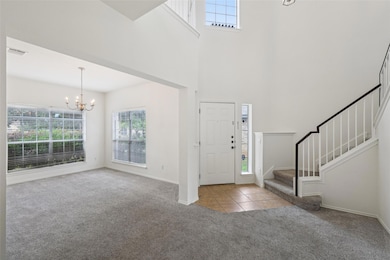 Carpeted entryway with a chandelier, healthy amou
