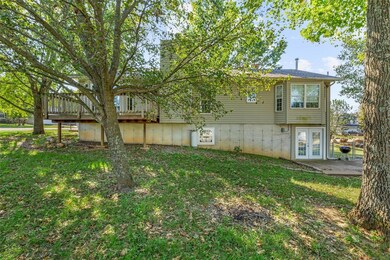 Rear view of property with a deck, french doors, a lawn, and a patio area