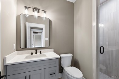 Bathroom featuring vanity, toilet, and a shower wi