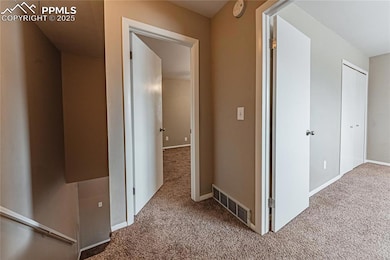 Corridor with carpet floors, baseboards, and visib