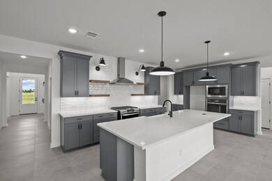 Gourmet kitchen with grey cabinets and quartz countertops