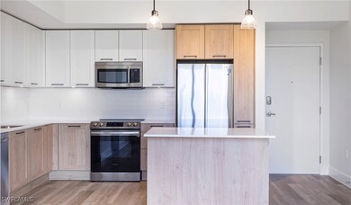 Kitchen featuring tasteful backsplash, light brown