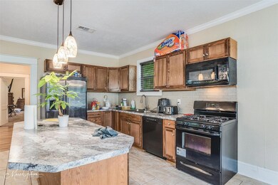Kitchen with black appliances, sink, crown molding
